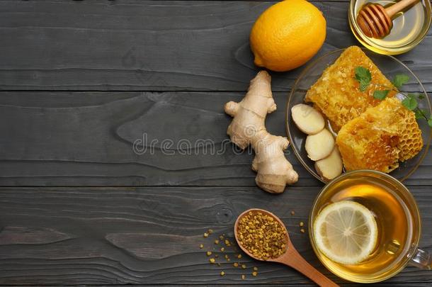 健康的背景.蜂蜜,蜂蜜comb,柠檬,茶水,姜向黑暗的