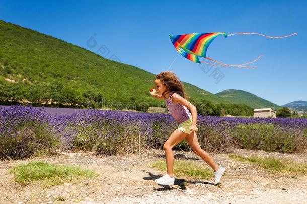 快乐的青春期前的女孩跑步和彩虹风筝