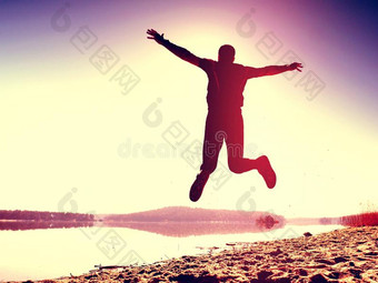 用于跳跃的男人.Sports男人疯狂的用于跳跃的和慢跑向海滩在的时候图片