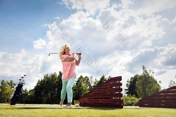 积极的较高的女人演奏高尔夫球.