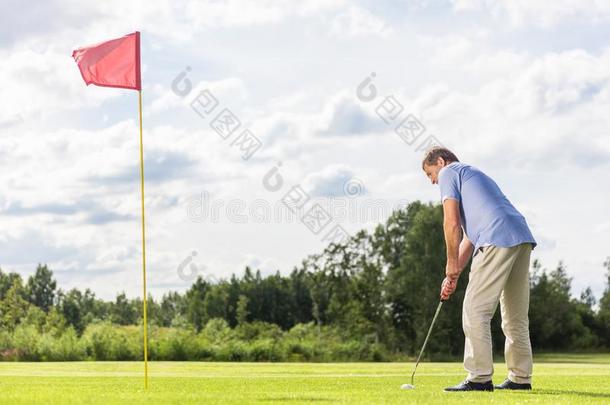 较高的男人演奏高尔夫球.