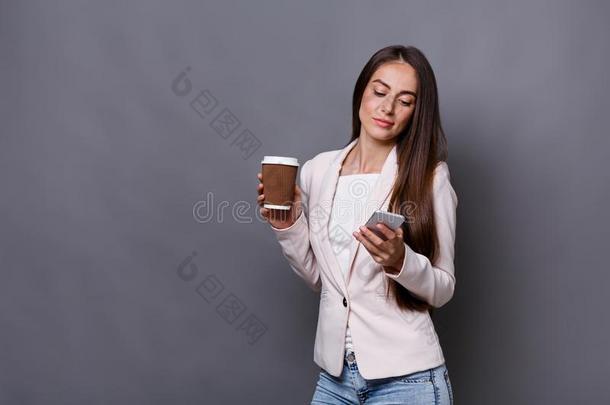 商业女人调用可移动的电话和饮料咖啡豆在使工作