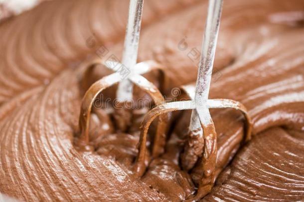 特写镜头宏指令混合巧克力掼奶油乳霜和手搅拌器