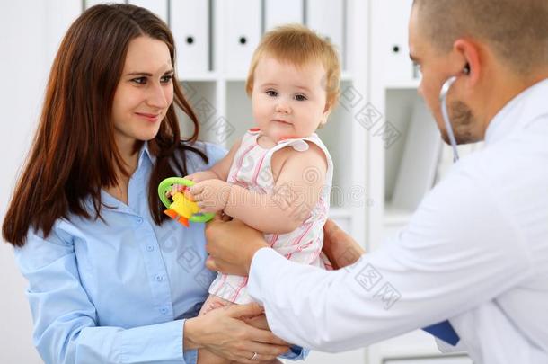 幸福的漂亮的婴儿和她mot她在健康状况考试在医生`英文字母表的第19个字母办公室