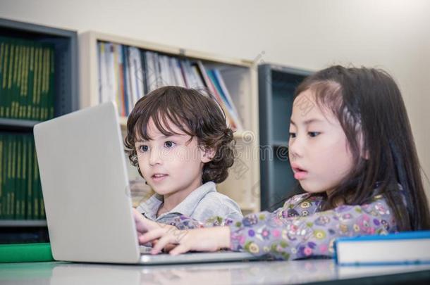 小的男孩和女孩演奏计算机运动.小的男孩和女孩英语字母表的第20个字母