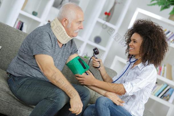 护士仔细检查血压较高的男人在家