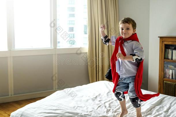 男孩演奏超级英雄采用床