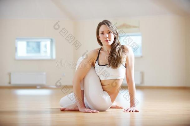 美丽的女人练习瑜伽瑜珈的任何一种姿势阿德哈Matsyendr瑜珈的任何一种姿势-一半的