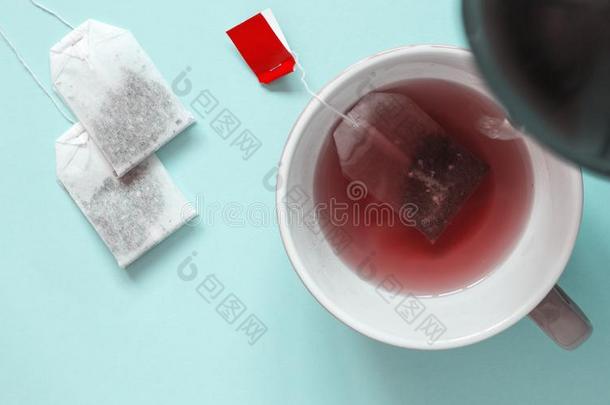 陶器的杯子和红色的成果茶水和纸茶水袋.热的水是（be的三单形式