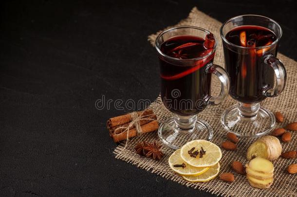将制成热饮葡萄酒横幅.眼镜和热的红色的葡萄酒和香料向黑暗的