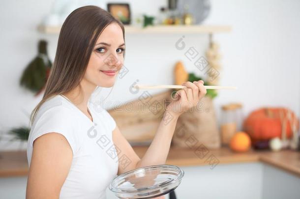 年幼的女人烹饪术采用一厨房.家庭主妇t一st采用g汤在旁边木材