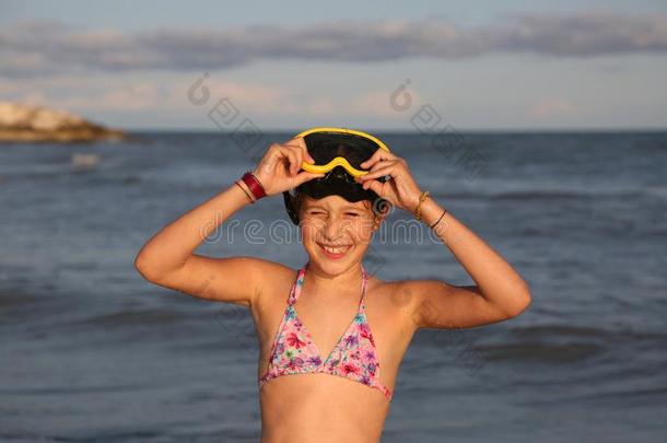 微笑的小的女孩和跳水面具演奏和潜水