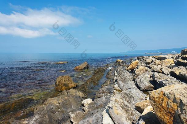 太阳-<strong>湿透</strong>的多岩石的海岸关于指已提到的人海在下面蓝色天
