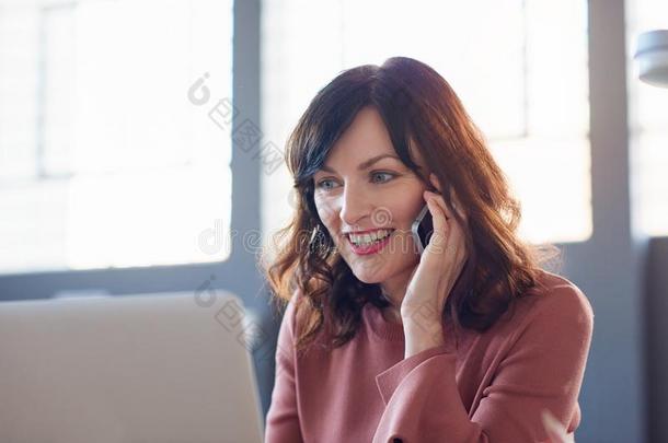 微笑的女商人工作的在她书桌采用一现代的办公室