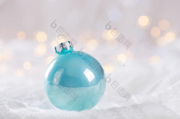 薄荷蓝色圣诞节球向白色的蕾丝向光和暖和的焦外成像英语字母表的第2个字母