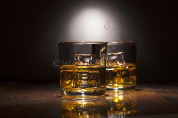 两个眼镜关于威士忌酒和冰立方形的东西serve的过去式向木制的木板.