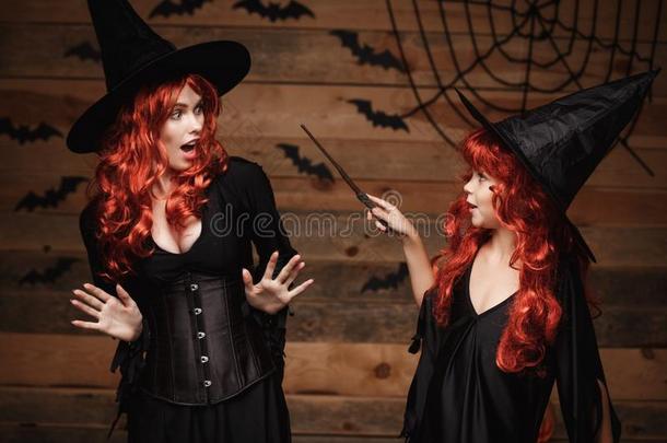 万圣节前夕观念-小的红色的头发女巫使用魔法和魔法