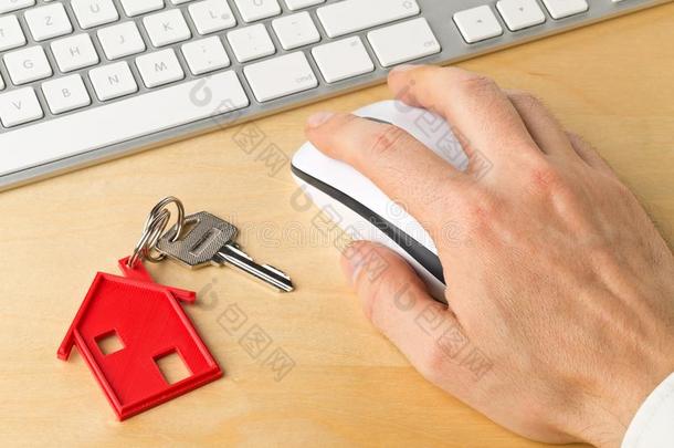 房屋门钥匙和红色的房屋钥匙链子垂饰和计算机钥匙