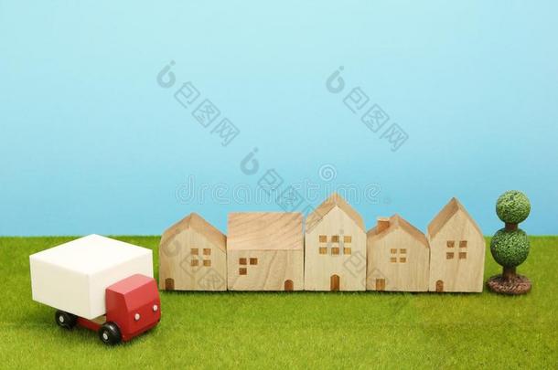 玩具汽车货车和住宅向绿色的草.