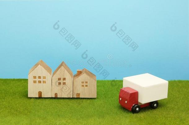玩具汽车货车和住宅向绿色的草.