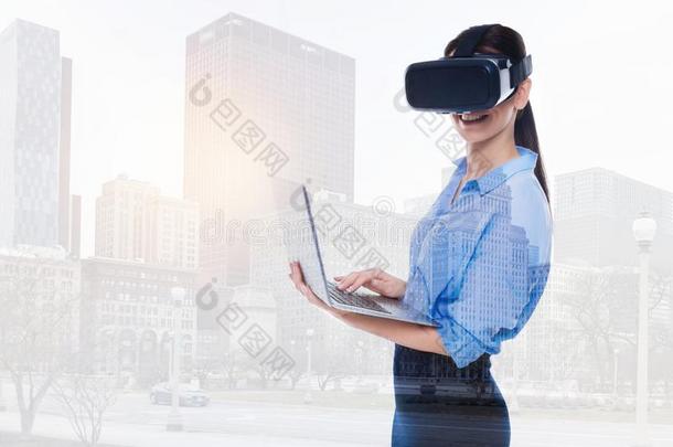 美丽的女人采用VirtualReality虚拟现实戴在头上的耳<strong>机</strong>或听筒<strong>pos</strong>采用g和便携式电脑