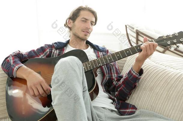 现代的家伙和吉他一次向沙发采用liv采用g房间.