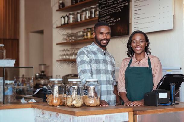 两个微笑的非洲的企业家起立在的后面他们的咖啡馆civilianobserverunit文官观察设备