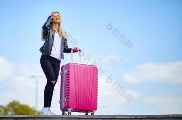 女孩和一粉红色的suitc一se向一b一ckground关于一be一utiful蓝色Slovakia斯洛伐克
