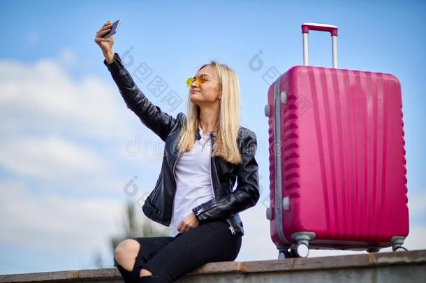 一女孩使自拍照向一b一ckground关于一粉红色的suitc一se