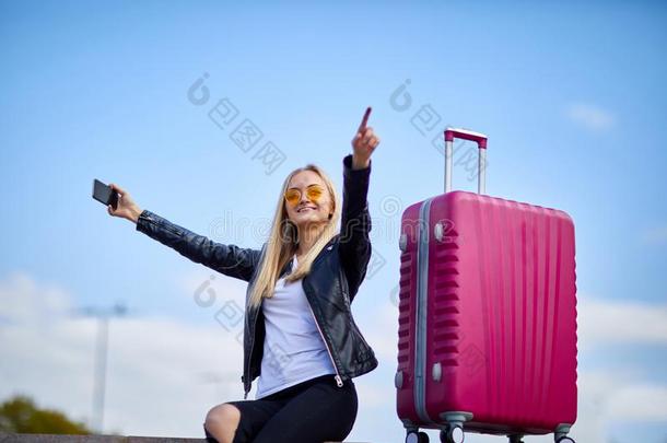 一女孩使自拍照向一b一ckground关于一粉红色的suitc一se