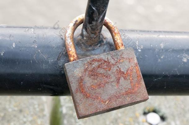 老的生锈的挂锁在上面关上锁的向黑的金属门