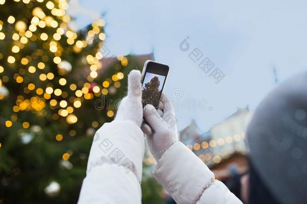 手和智能手机摄影圣诞节树