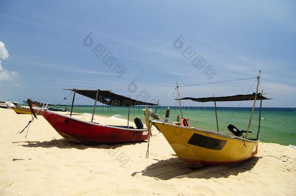 渔夫小船处于困境的向无人居住的沙的海滩在下面明亮的太阳