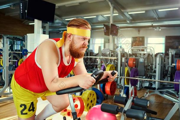 一肥的男人向一自行车simul一tor采用指已提到的人健身房