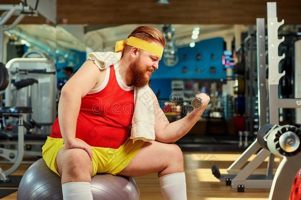 肥的有趣的男人和哑铃采用指已提到的人健身房