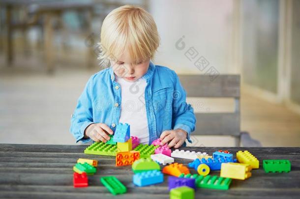 小的男孩演奏和富有色彩的塑料制品建筑物赛跑者起跑时脚底所撑的木块
