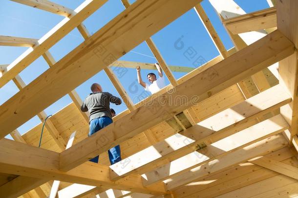 建设者在使工作和木制的屋顶建筑物.