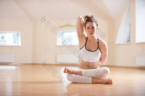 美丽的女人练习瑜伽瑜珈的任何一种姿势Gomukh瑜珈的任何一种姿势-奶牛面容使摆姿势