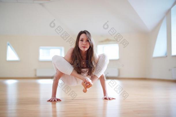 美丽的女人练习<strong>倒立瑜伽</strong>瑜珈的任何一种姿势BhujaPid瑜珈的任何一种姿势-