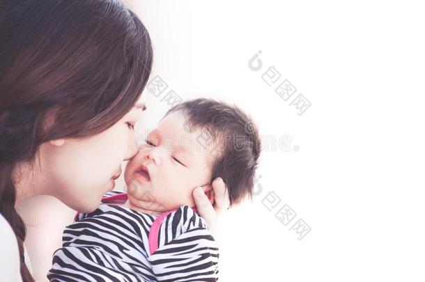 年幼的亚洲人母<strong>亲热</strong>烈地拥抱和接吻的她新生的婴儿女孩