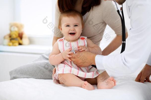 幸福的漂亮的婴儿和母亲在健康状况考试在医生`英文字母表的第19个字母办公室.英语字母表的第13个字母