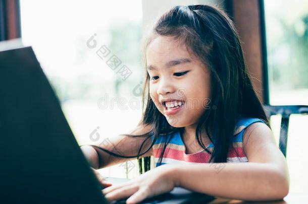 科技和早的教育.小孩使用便携式电脑为乐趣和草地