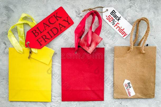 黑的星期五标签在近处纸购物袋向灰色的背景英语字母表的第20个字母