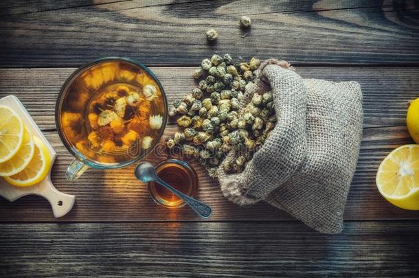 甘菊茶水杯子,粗麻布袋关于干的干燥的雏菊花,蜂蜜罐子一