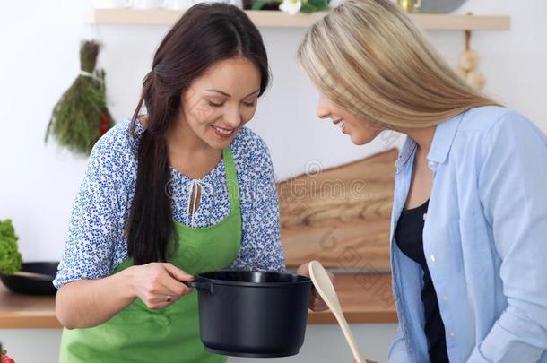 两个年幼的幸福的女人是烹饪术采用指已提到的人厨房.朋友是int.哈