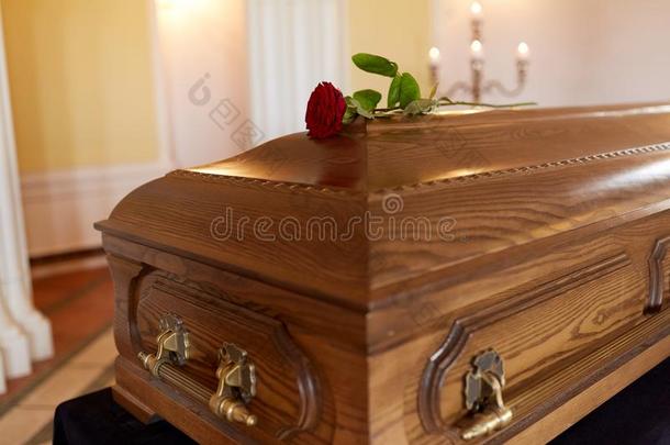 红色的玫瑰花向木制的棺材采用教堂