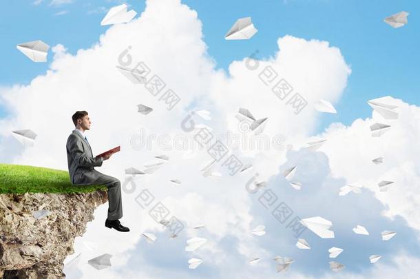 男人向边阅读书和纸位面飞行的采用天空
