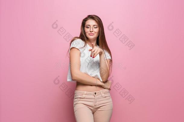 漂亮的年幼的时尚感觉的女人使摆姿势向粉红色的背景digitalrectalexam数字反映测试