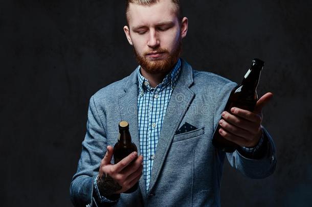 一男人打扮好的采用一一套外衣保存一瓶子和cr一ft啤酒.