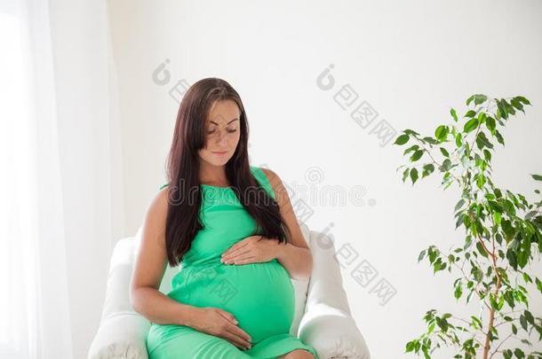 一怀孕的女人在之前分娩坐采用白色的长沙发椅